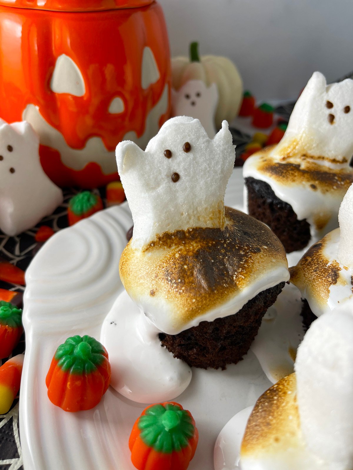 Toasted marshmallow creme topped cupcakes with ghost peeps on top.