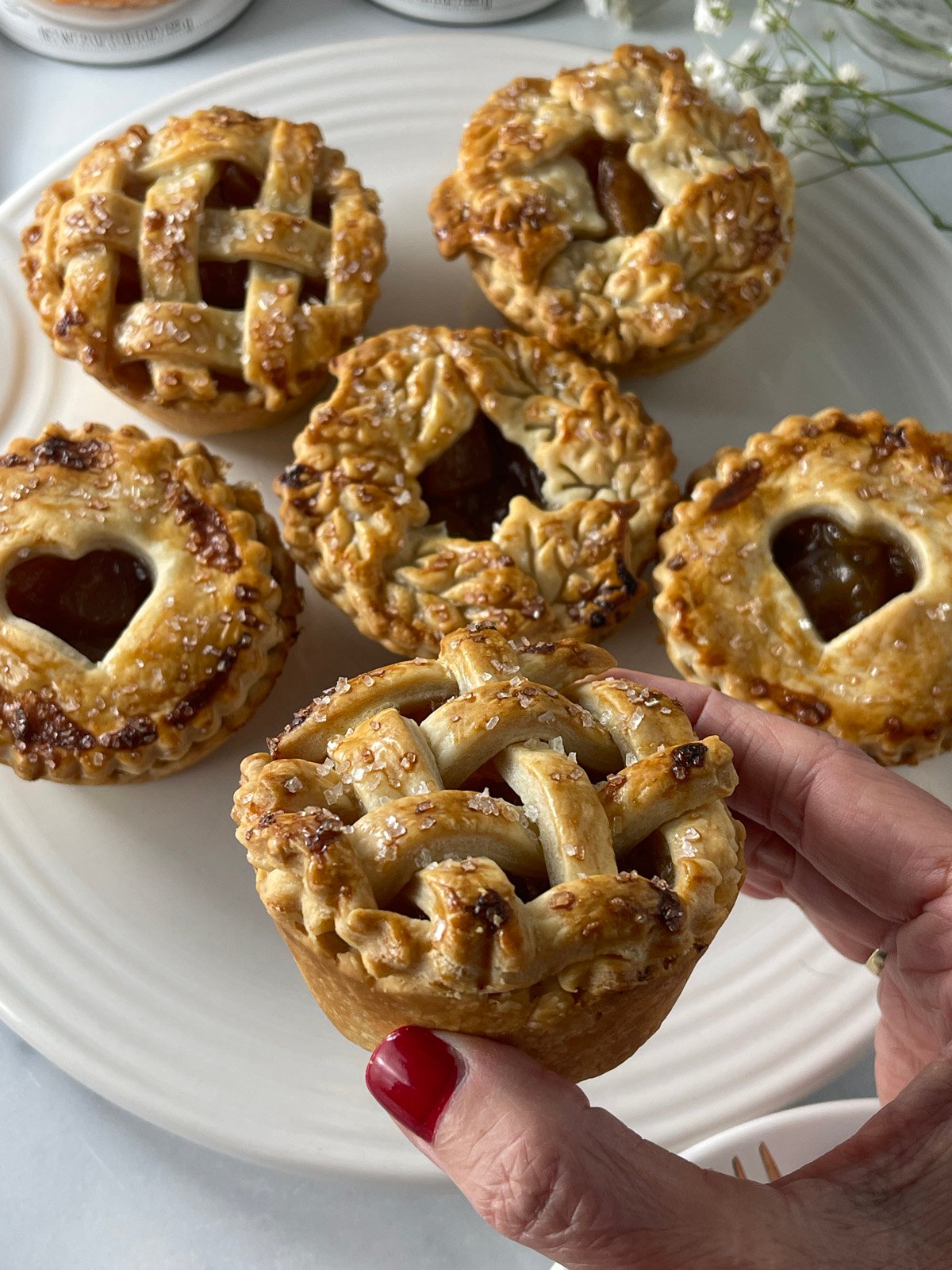 Caramel apple mini pies with different pie dough designs.