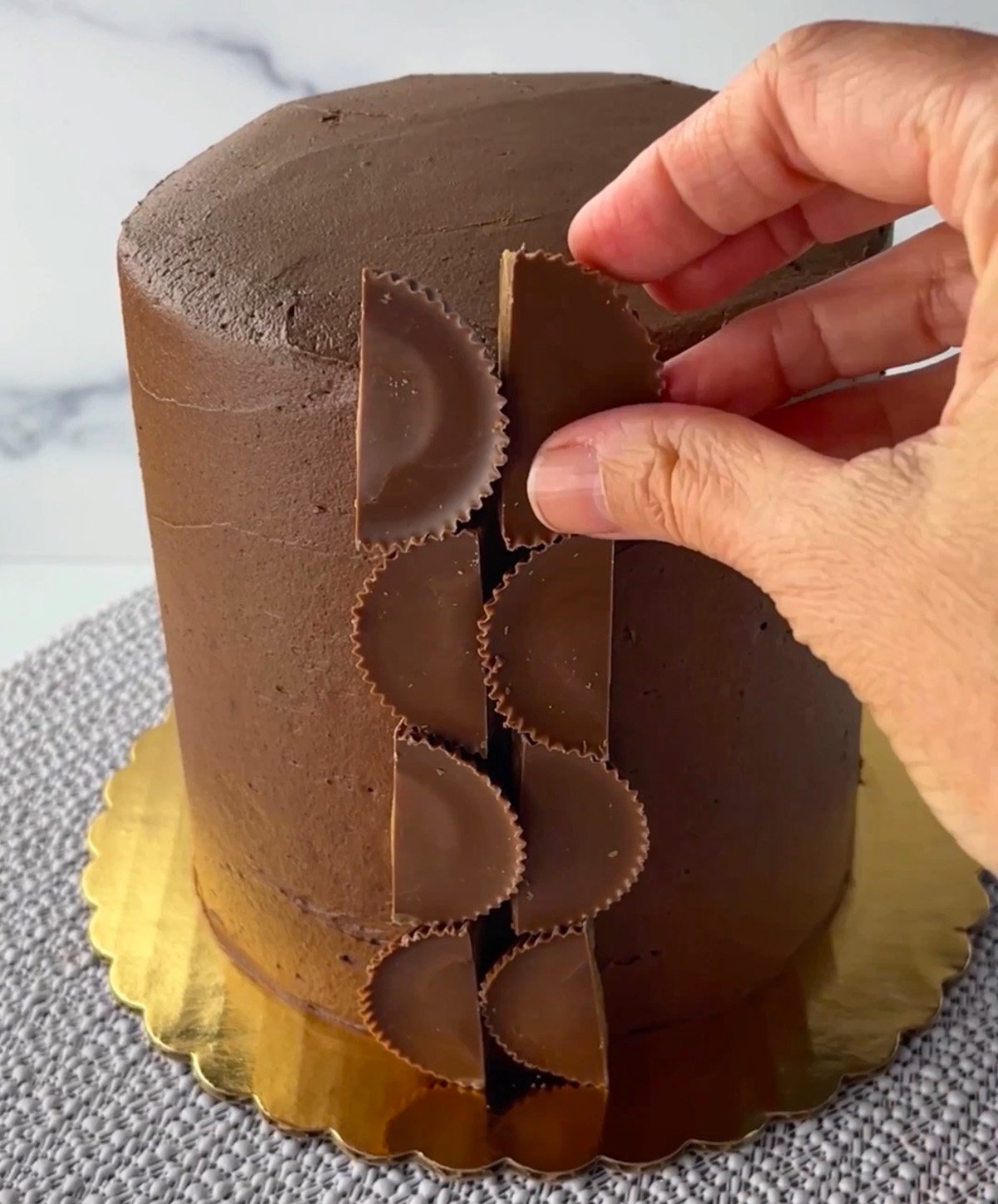 Adding Reese's peanut butter cups to chocolate layer cake.
