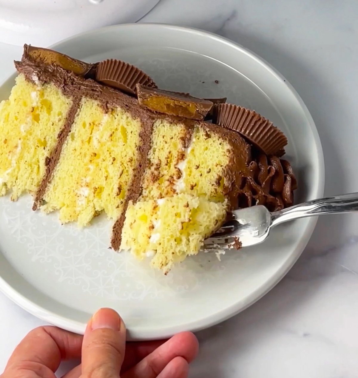 Slice of yellow cake with chocolate frosting.