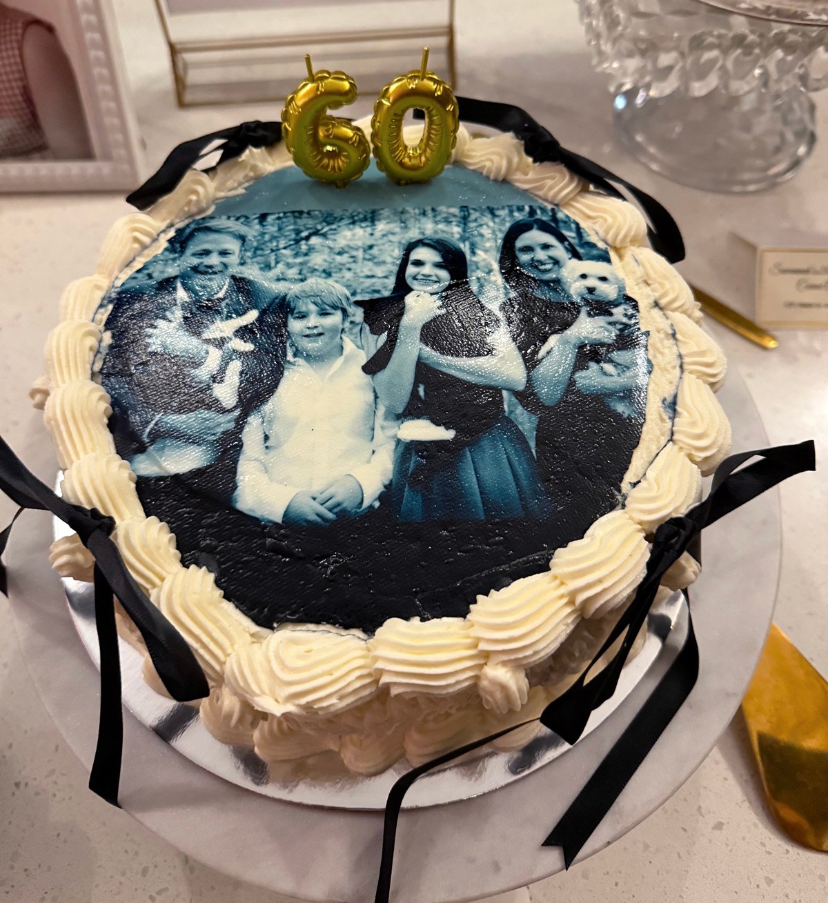 Sixtieth birthday cake with edible family photo on top and 60 candles.