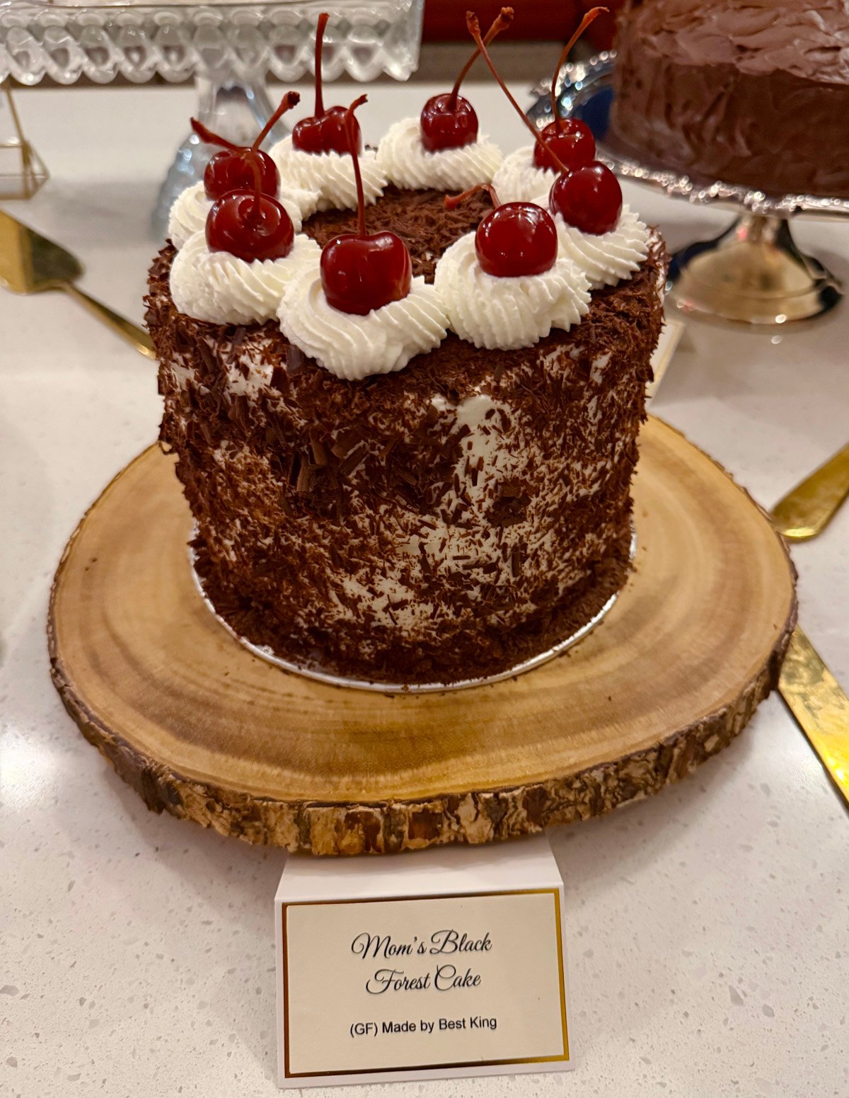 Black forest cake with chocolate shavings and cherries on top,