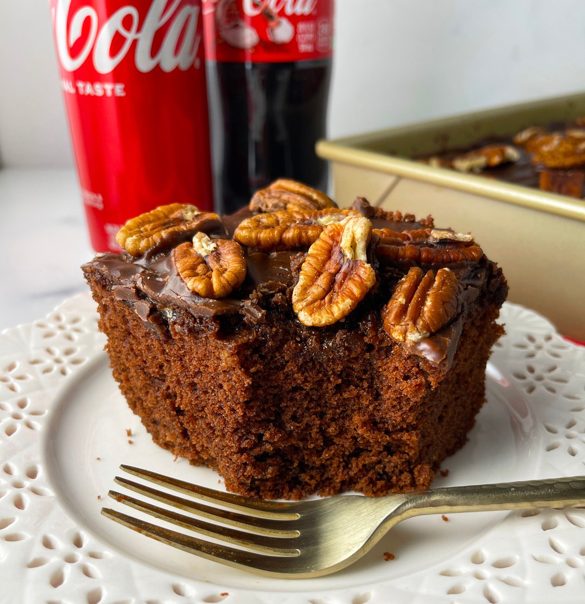 Southern coca cola cake served on plate with fork and bite.