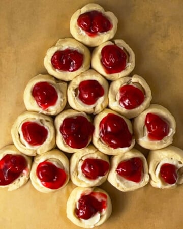 Cherry danish shaped like Christmas tree on baking pan ready to bake.