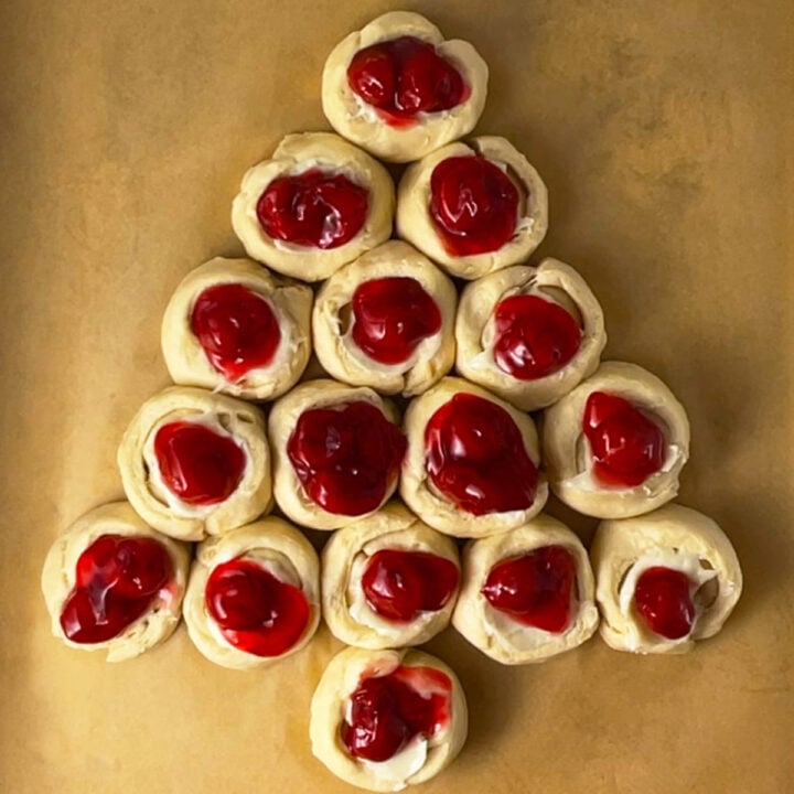 Cherry danish shaped like Christmas tree on baking pan ready to bake.