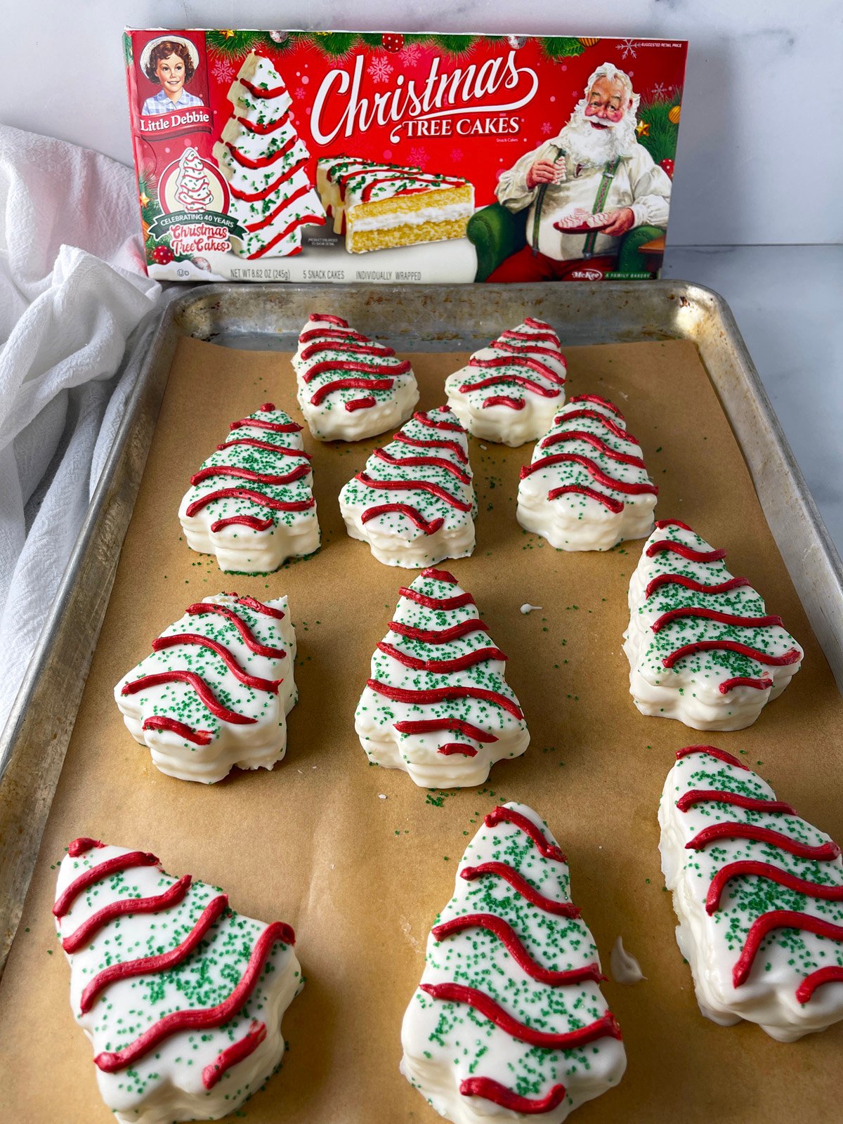 Homemade little debbie tree cakes on a sheet pan with parchment.