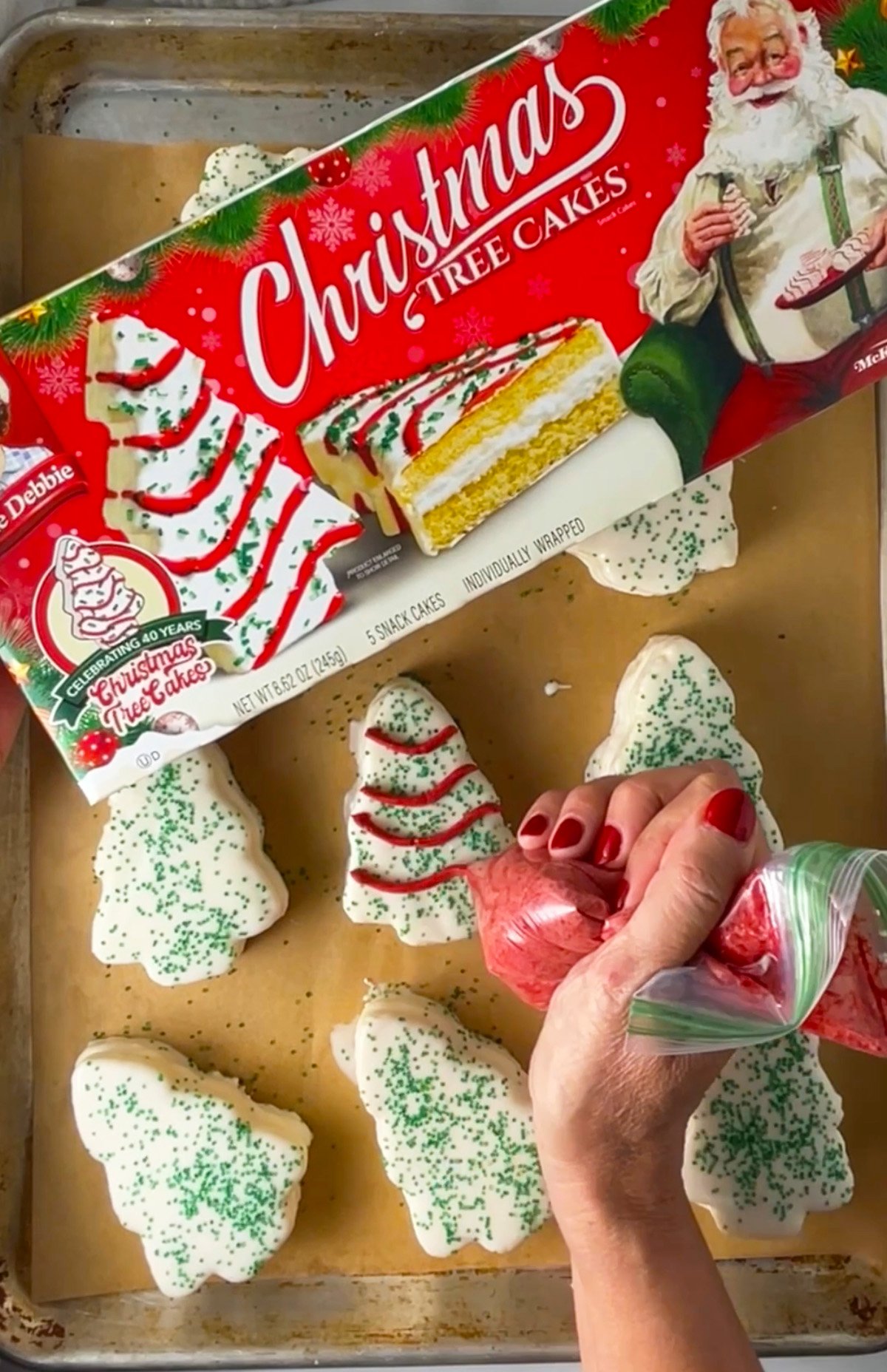 Piping red icing stripes on homemade Christmas tree cakes like little debbie makes.