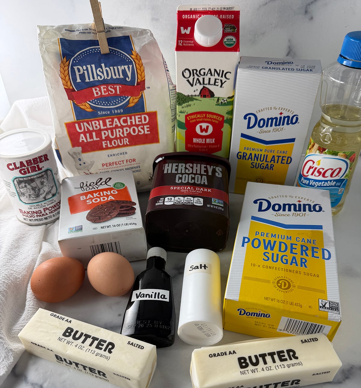 Ingredients needed to make homemade heart shaped chocolate cake with buttercream frosting.