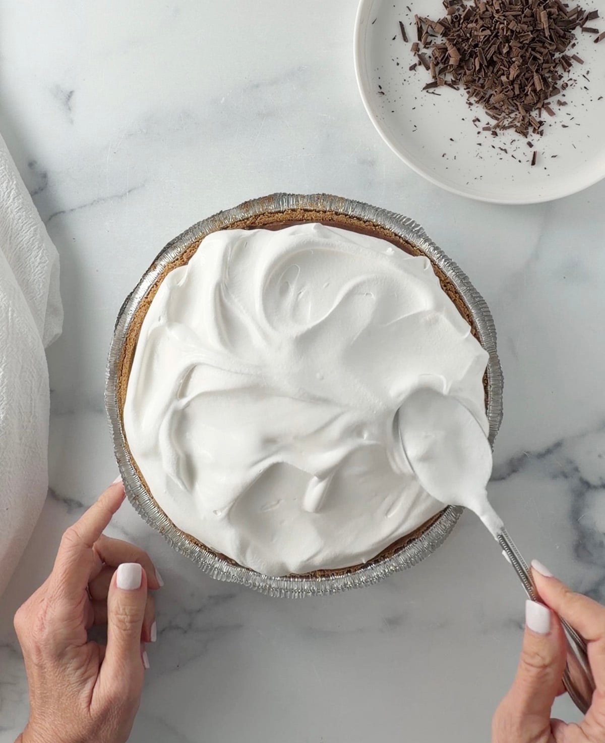 Spreading cool whip on pie.