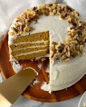 Autumn gold pumpkin cake on a wooden cake platter.