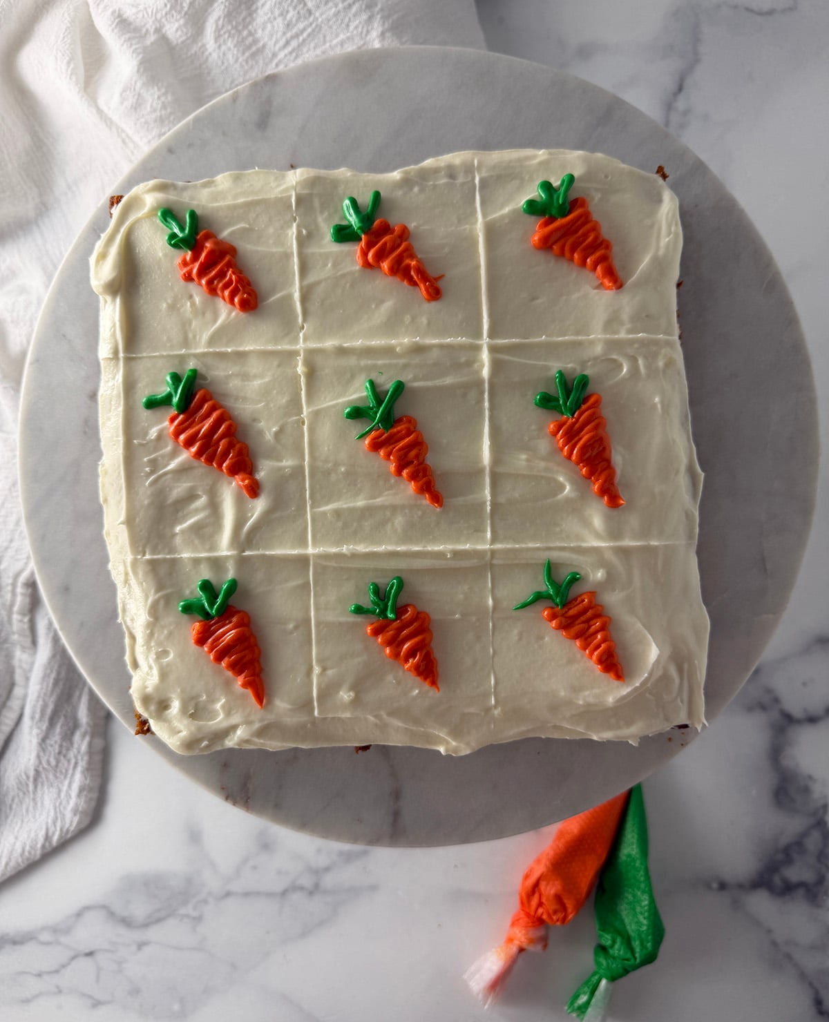 Decorating carrot yogurt squares with orange icing carrots and green icing leaves.