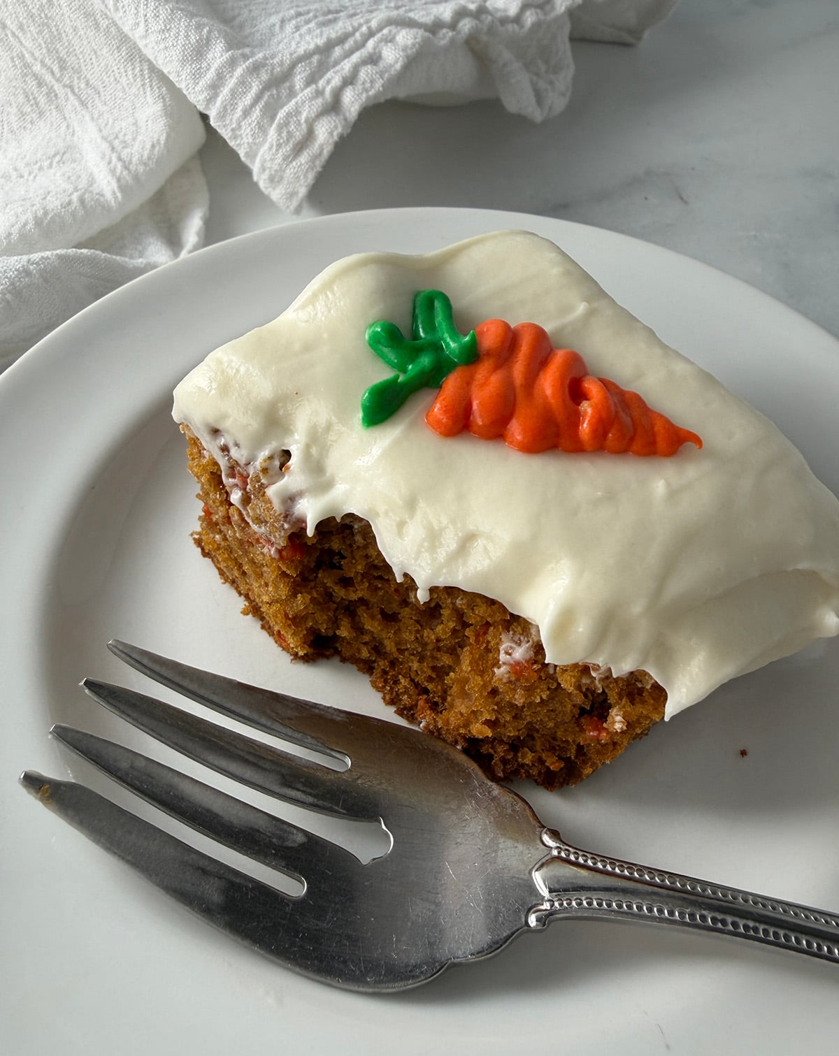 One serving of carrot yogurt squares with fork.