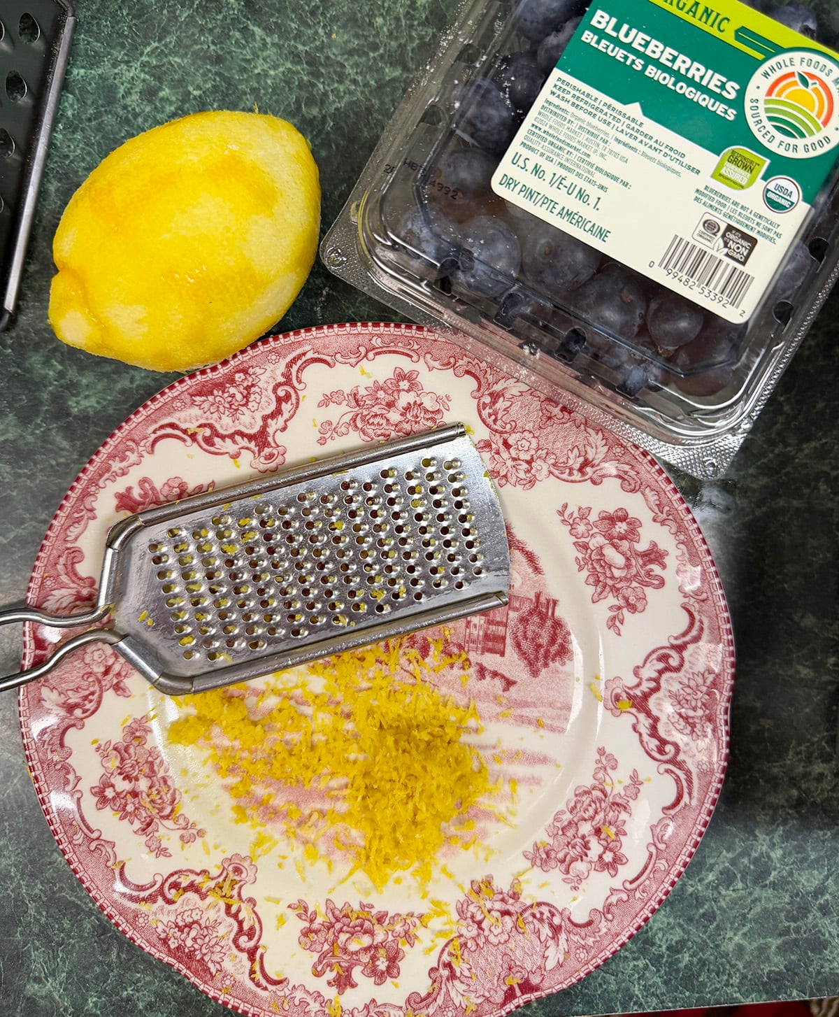 Photo shows grated lemon zest on a plate with the grater.
