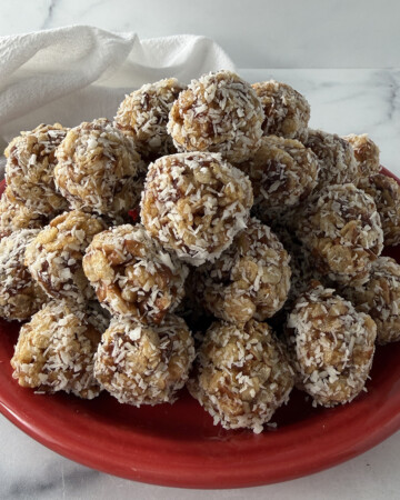 Old fashioned date nut balls on a red plate.
