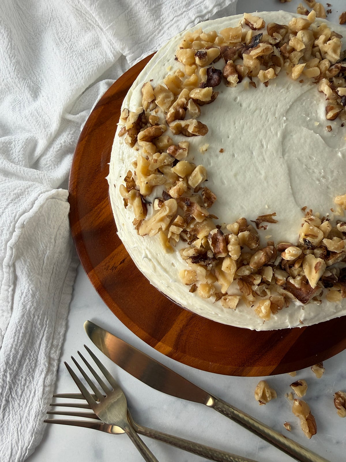 Beautiful pumpkin cake with cream cheese frosting and walnuts on top.