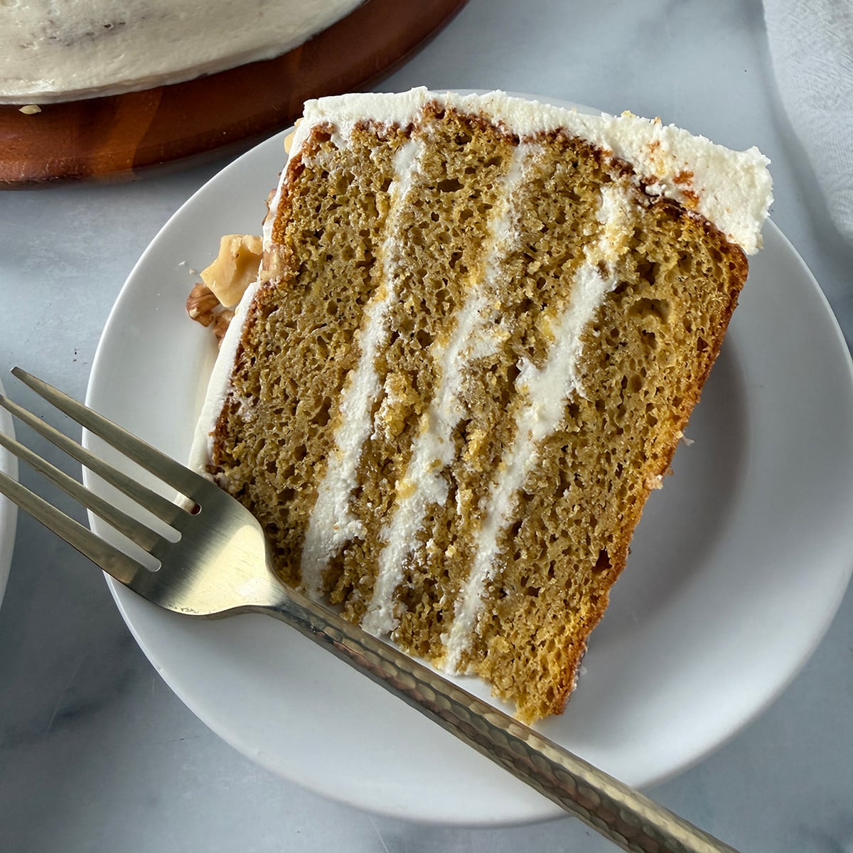 Slice of pumpkin cake with cream cheese frosting.