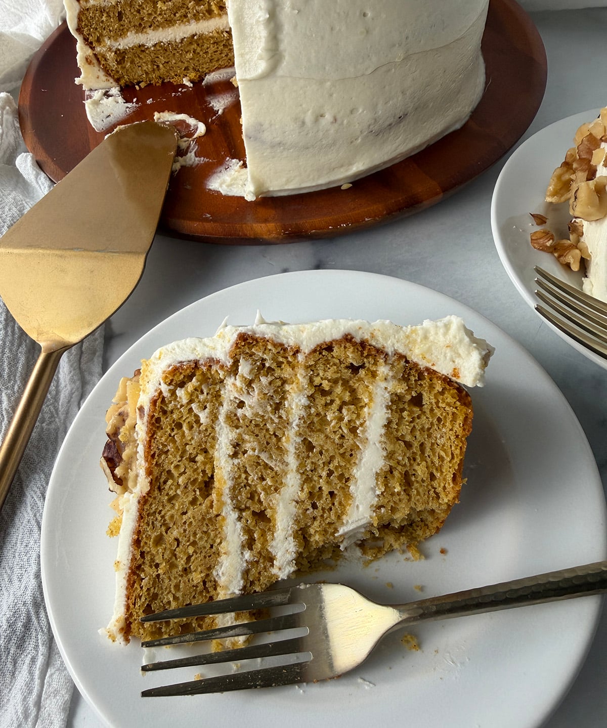 Pumpkin cake slice with bite taken out and gold fork.